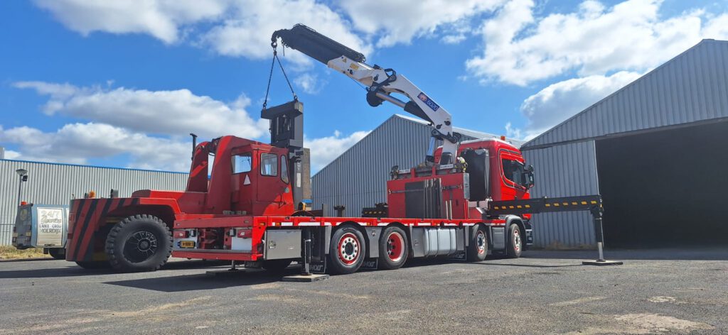 Autolaadkraan met grote machine.