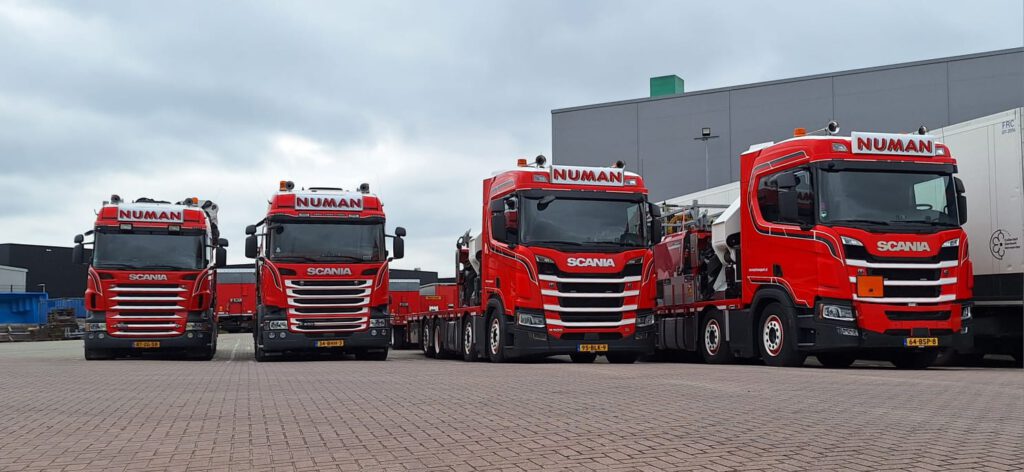 Vier Numan Transport vrachtwagens naast elkaar geparkeerd.