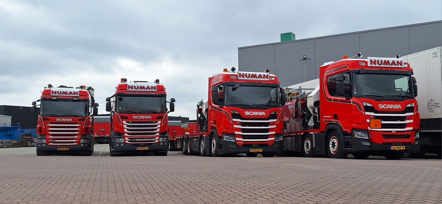 Vier Numan Transport vrachtwagens naast elkaar geparkeerd.