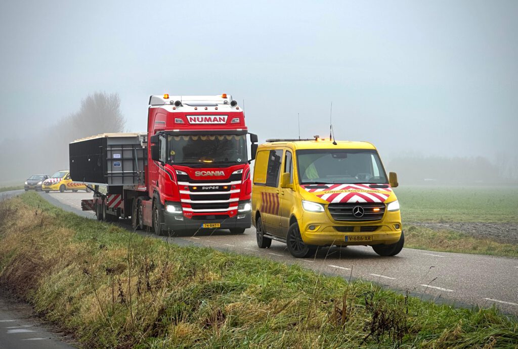 Numan vrachtwagen met begeleidingsbus voor exceptioneel vervoer van zwembad. 